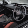 CX-30  インパネのミドルパッドは、ベース車のBlack Tone Edition が黒い合成皮革なのに対して、Retro Sports Edition はシートのメイン材と同じスエード調人工皮革。その下の金属調加飾もサテンクロームからガンメタに変更している  加飾のトーンを下げることで、室内全体のテラコッタ＆ブラックのコントラストを際立たせているのだ