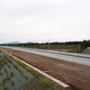 道路として完成した片側一部区間（手前が未開通）