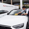 ディーラーのスタッフが手洗いで洗車を行う