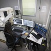 2500倍まで確認できるデジタル光学顕微鏡で金属の表面を確認。そこで確認できなかった場合は1万倍まで確認できる電子顕微鏡（写真）で検証する。コーティングなのか、素材なのか、製造方法なのか、原因を探っていく。