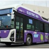 江戸紫色の車体に大きなプラグを描いたEVバスの外観