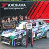 参戦車両とチームメイトの前で表彰盾を掲げる田口勝彦選手
