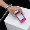 スマートフォン「AQUOS PHONE f SH-13C」（シャープ製）と、ワイヤレス充電器「ワイヤレスチャージャー 01」の組み合わせ。置くだけで充電を可能にした