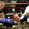 AMGエンジンの組み立てに挑戦するF1ドライバーのミハエル・シューマッハ選手と、ニコ・ロズベルグ選手