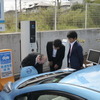 ジャパンネットワーク代表取締役の武田二郎氏とファミリーマート常務執行役員の本多利範氏が充電デモを行った。