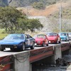 前から順にフェラーリ・308GT4、トヨタ・スポーツ800、ポルシェ・911、ブリティッシュレイランド・ミニ1000バン・アルファロメオ・ジュリア1300ti