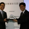 記念品の交換を行った上海GM・ゼネラルディレクターのケビン・チェン氏(右)とBOSEオートモティブ　システムズ事業部マーケティング ダイレクタージョン・マー氏(左)