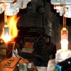 ハロゲンランプの製造ライン。ピンチングと呼ばれるガラス管にフィラメントを挿入し、下部を封入する工程。上の細い管はあとでガスを注入するために使う