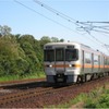 東成岩駅付近を走る武豊線の気動車。既に架線柱の設置と架線の敷設が完了している。