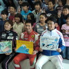 見学に訪れた小学生たちと日本人ドライバーの記念撮影。前列右から中嶋一貴、小林可夢偉、井原慶子。