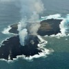海上保安庁が2013年12月26日に撮影した西之島（奥）と新しい島（手前）。新しい島の急速な拡大で両島がつながった。