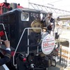 嵯峨野トロッコ列車の年間利用者数が3月19日、初めて100万人を突破した。写真は記念のヘッドマークを取り付ける乗客代表ら