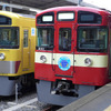 黄色い一般塗装の9000系（左）と並んだ「RED LUCKY TRAIN」