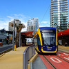 サーファーズパラダイス駅（Surfers Paradise Station）に停車するトラム（Tram G:link）。35km/h制限の併用軌道区間に位置する。