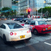 九龍・香港島エリアをネットするトヨタ『クラウンコンフォート』タクシーと、その左に並ぶ日産『GT-R』
