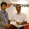 インド赤十字社のピー・シー・パルティハリ副長官（右）に義援金を手渡す藤津聡YIN社長
