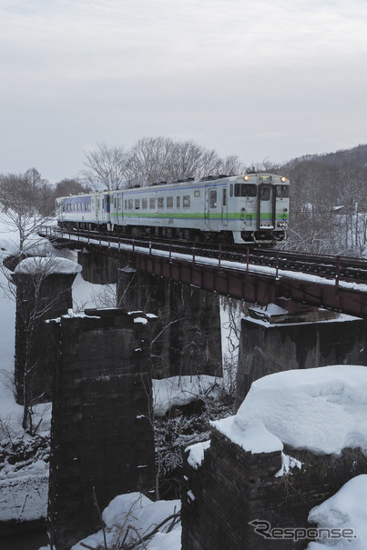 清水沢～鹿ノ谷間を行く下り列車。清水沢駅に近いこの志幌加別川付近は、手前に夕張支線がかつて複線であったことを物語る橋脚が残されている。2019年3月27日。