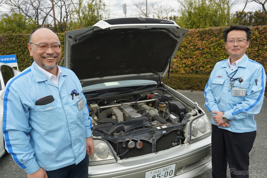 初代パフォーマンスダンパーと、ヤマハ発動機 AM事業部 原田豊二さん（左）とモビリティ技術本部 飯倉雅彦さん（右）