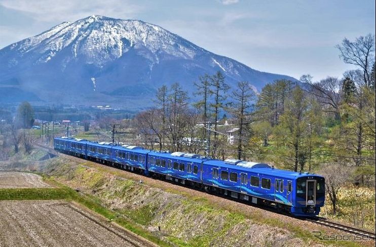 北しなの線古間～黒姫間を走るSR1系の試運転列車。車体色は「沿線に爽やかな新風を」をコンセプトに、ロイヤルブルーと115系のDNAを承継したというシャンパンゴールドの組合せとなり、側面には山並と清流を表現した緑と水色のラインが入っている。