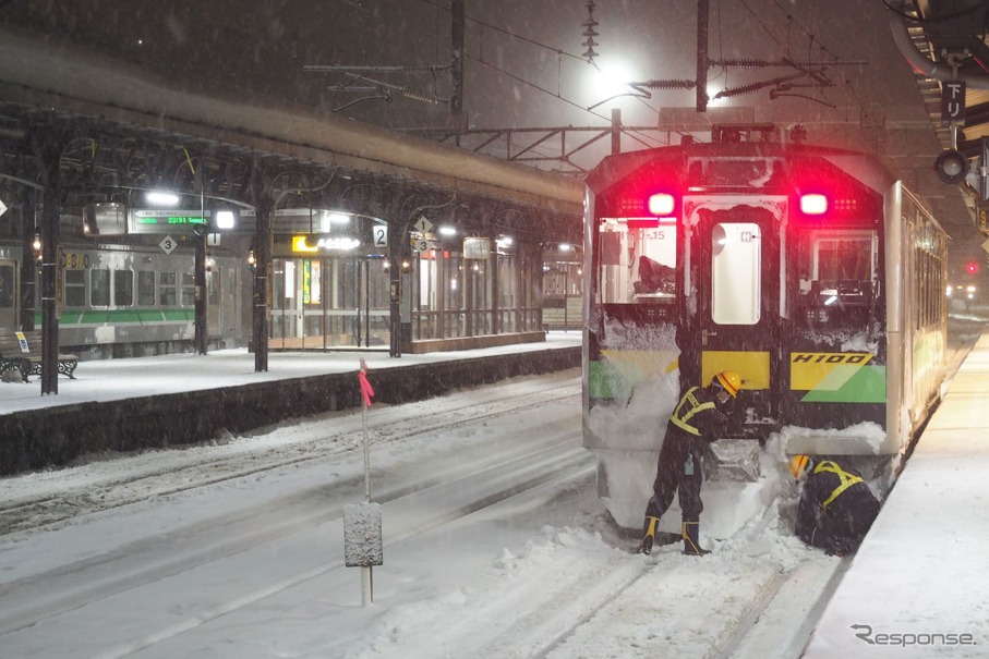 北海道内は年末年始にかけて厳寒と大雪に見舞われたが、連休明けの1月11日は夜半にかけて再び大雪の予報が出ている。写真は2022年1月2日、函館本線小樽駅に停車中のH100形を除雪する社員。