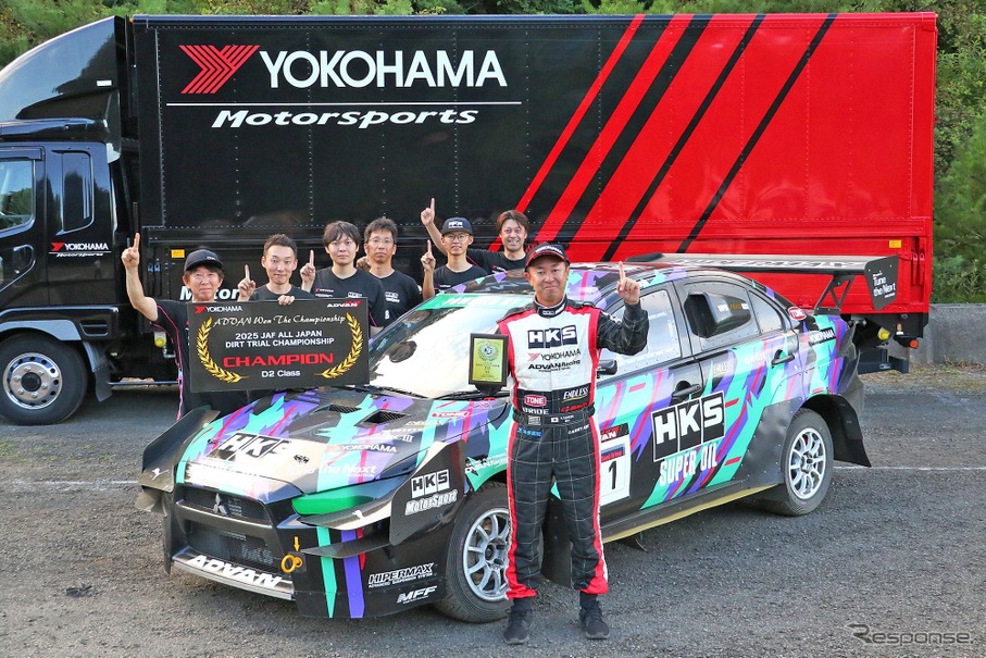 参戦車両とチームメイトの前で表彰盾を掲げる田口勝彦選手